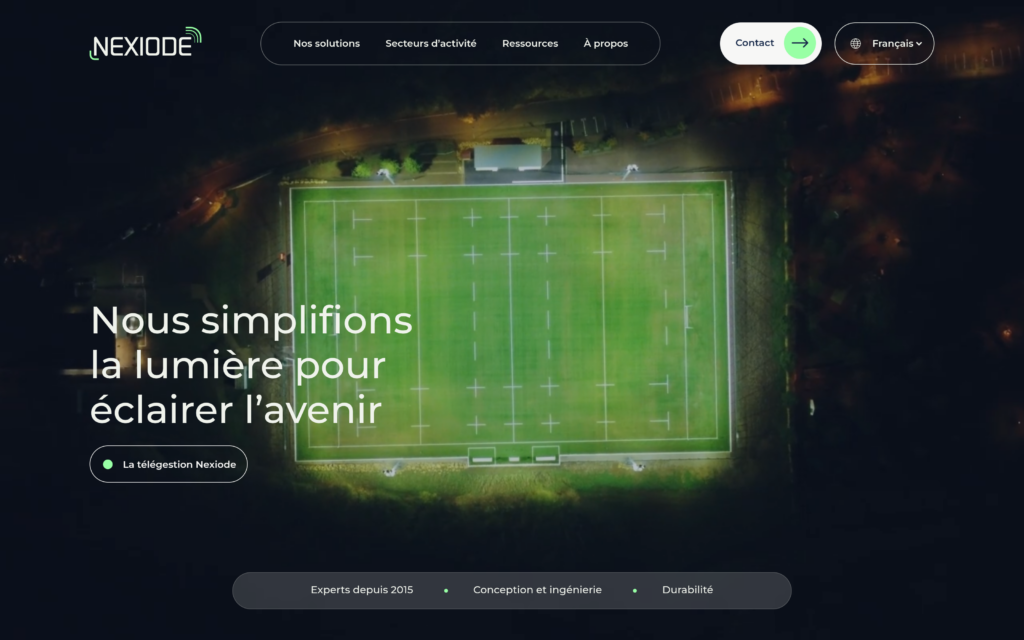 Page d'accueil du site WordPress de Nexiode : vue aérienne nocturne d'un terrain de sport éclairé, sous le titre « Nous simplifions la lumière pour éclairer l'avenir »